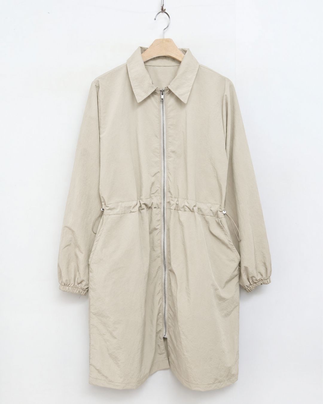 Chamuleのベージュのロング丈ゴルフジャケット。ウエストギャザーとフルジップ仕様で女性らしいシルエット。