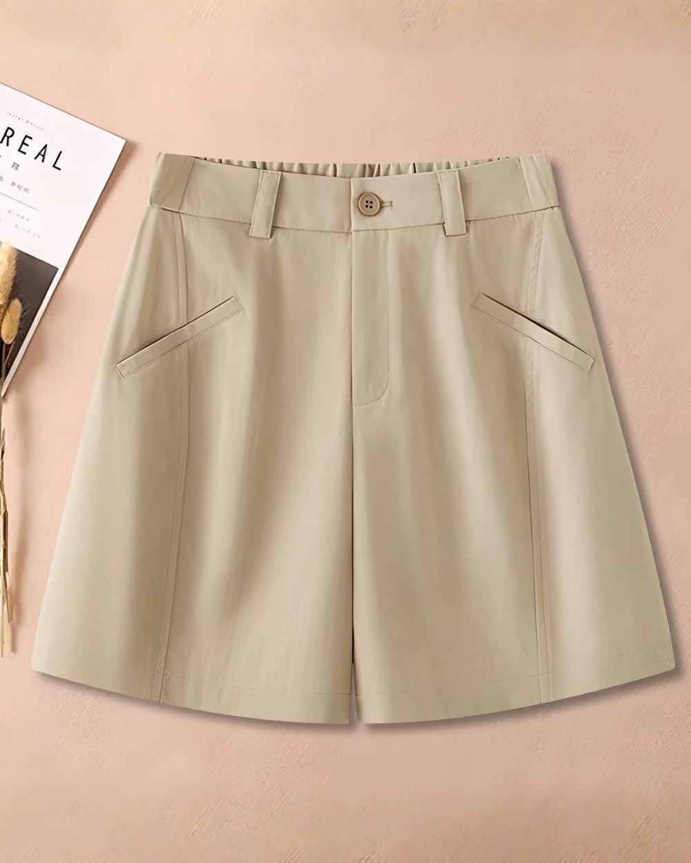Chamuleのベージュカラーのワイドシルエットショートパンツ。ゴルフウェアとして最適なシンプルで洗練されたデザインのベルトループ付きパンツ。