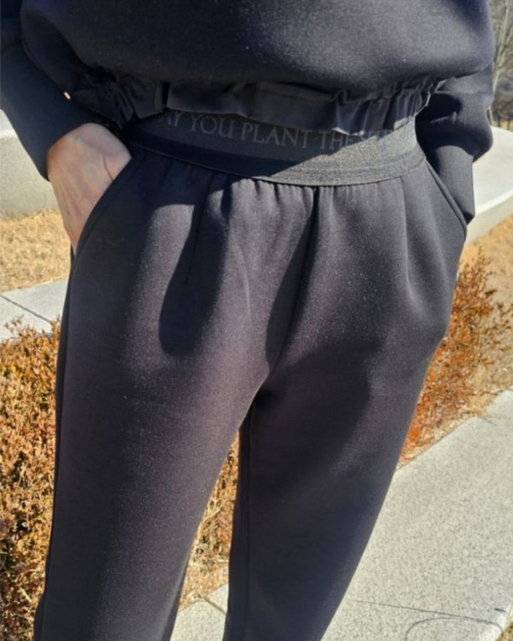 Chamuleのブラックのストレートワイドゴルフパンツ。ウエストにロゴ入りゴムバンドを配した動きやすいポリエステル混紡素材のボトムス。