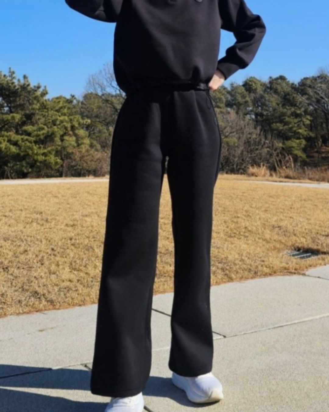 Chamuleのブラックのストレートワイドゴルフパンツ。動きやすいポリエステル混素材で、ゴルフ場でのラウンドや行き帰りに適した上品なシルエット。