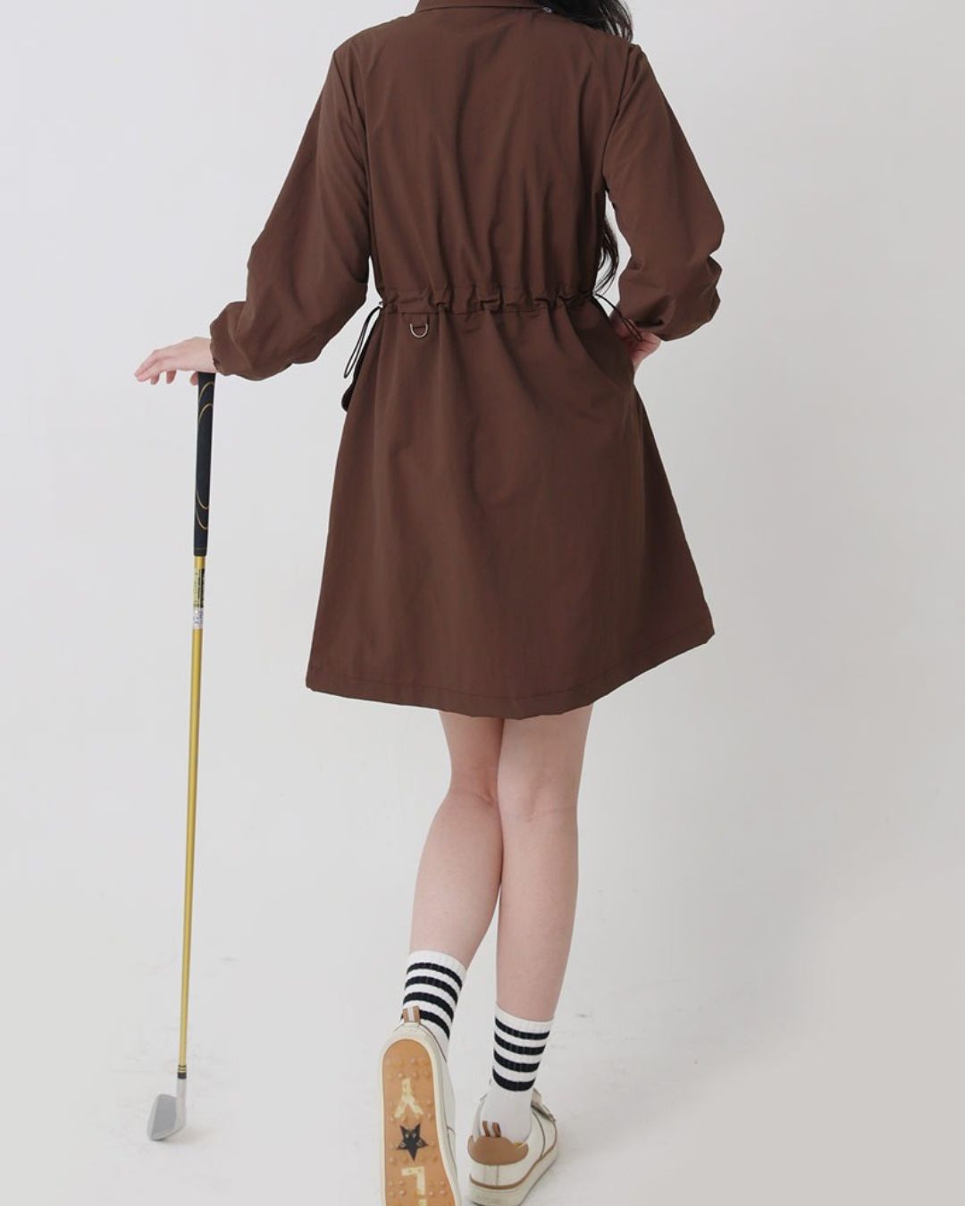 Chamuleのブラウンのロング丈ゴルフジャケット。ウエストギャザーでシェイプされた女性らしいシルエットのナイロン製アウター。