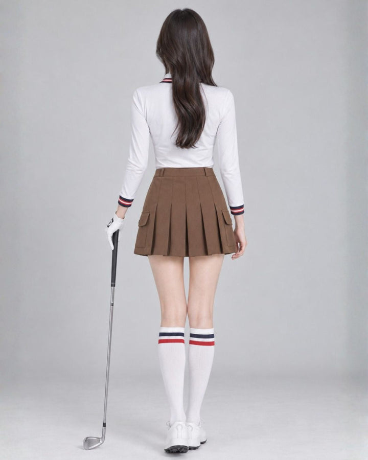 Chamuleのブラウンのカーゴポケット付きプリーツスカートを着用し、ゴルフウェアでポーズをとる女性の後ろ姿