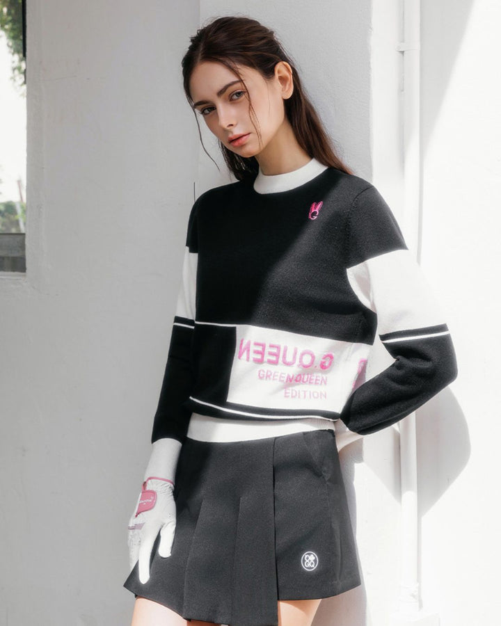 Chamuleのブラックとホワイトのカラーブロックロゴニットトップスを着用した女性ゴルファー