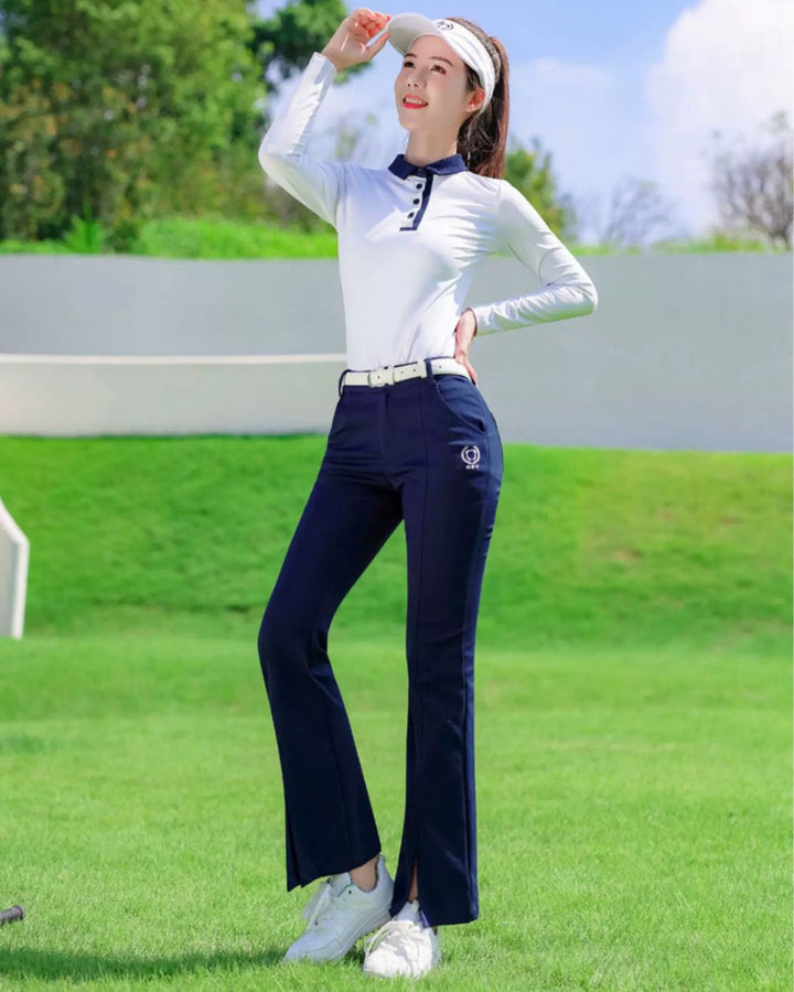 Chamuleの美シルエットフレアゴルフパンツを着用し、ゴルフ場でポーズをとる女性。ネイビーのフレアパンツが脚を長く見せ、スポーティーで上品なスタイルを演出。