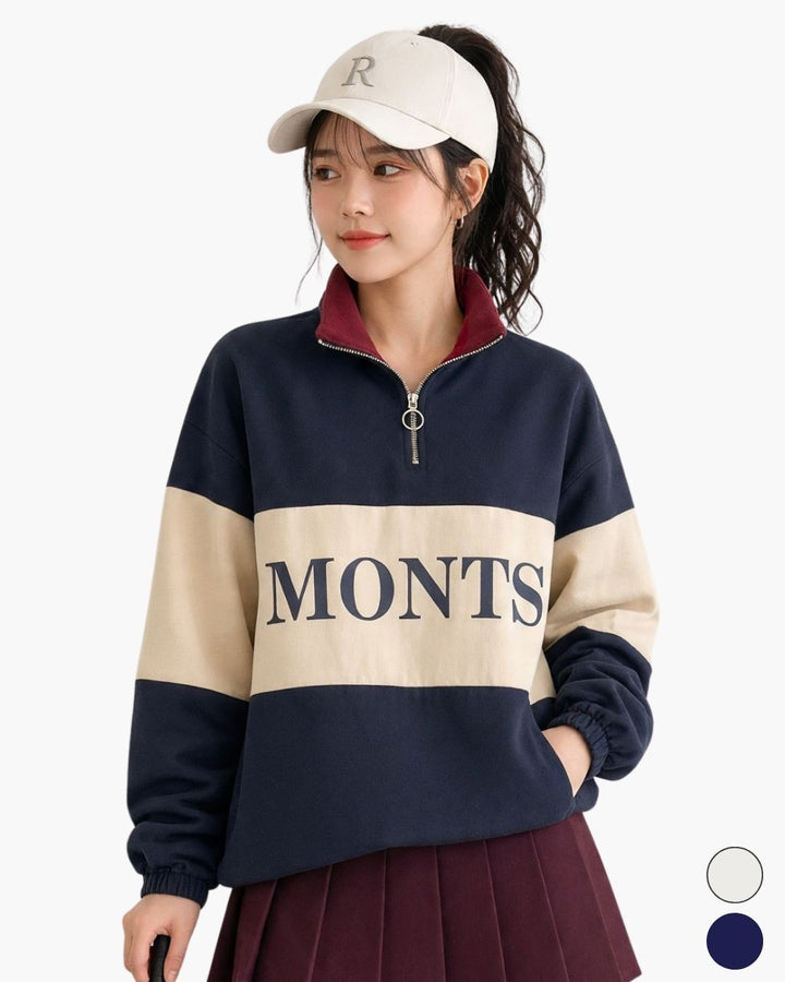 Chamuleの配色ロゴ入りハーフジッププルオーバーを着用した女性。ネイビーとベージュの切り替えデザインが特徴的な綿素材のゴルフウェア。
