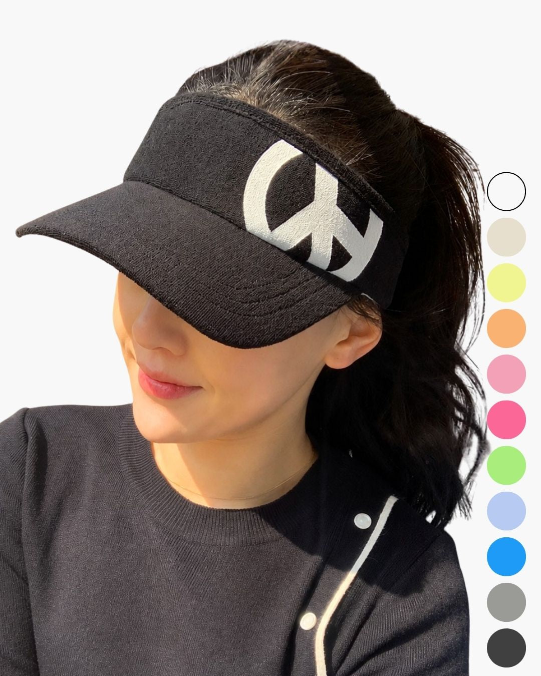 Chamuleのカラフルなロゴが刺繍された黒い綿100%のスポーティーなゴルフ用サンバイザーを着用した女性
