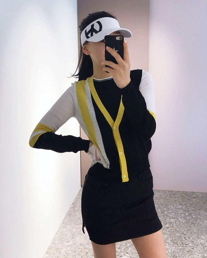 Chamuleのロゴ入りホワイトサンバイザーを着用し、ゴルフウェアでコーディネートした女性の鏡越しショット