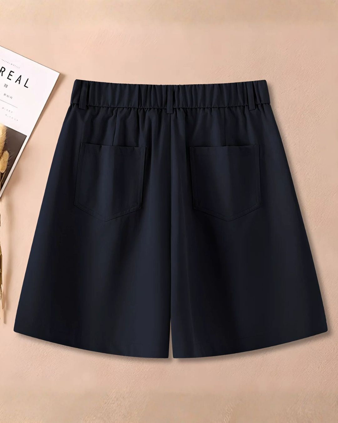 Chamuleのネイビーカラーのワイドシルエットショートパンツ。ゴルフウェアとして最適なシンプルで洗練されたデザインのバックショット。