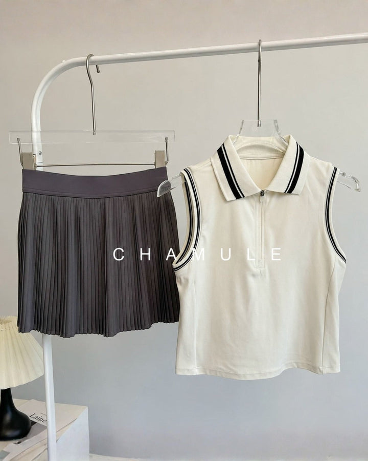 Chamuleのカラフルプリーツセットアップ。ホワイトの襟付きノースリーブトップスとグレーのプリーツスカートの組み合わせ。