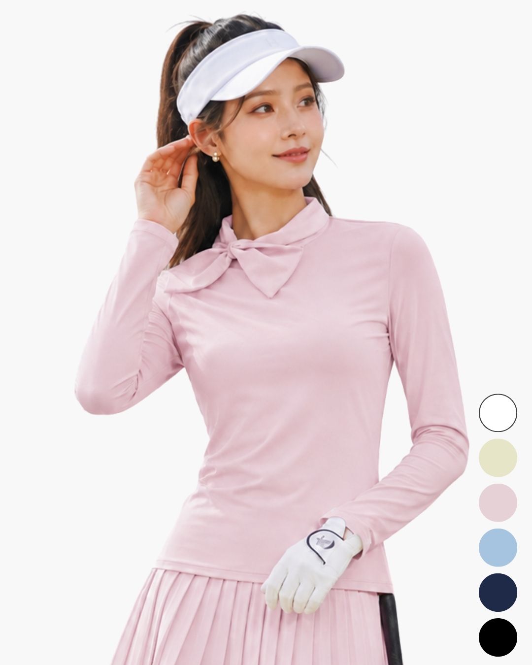 Chamuleの首元に大きなリボンをあしらったフェミニンなピンクの長袖ゴルフトップスを着用した女性