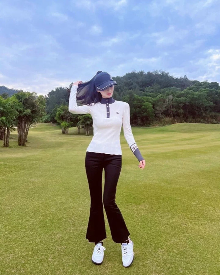 Chamuleの裏起毛スリムフレアゴルフパンツを着用し、ゴルフ場でポーズをとる女性