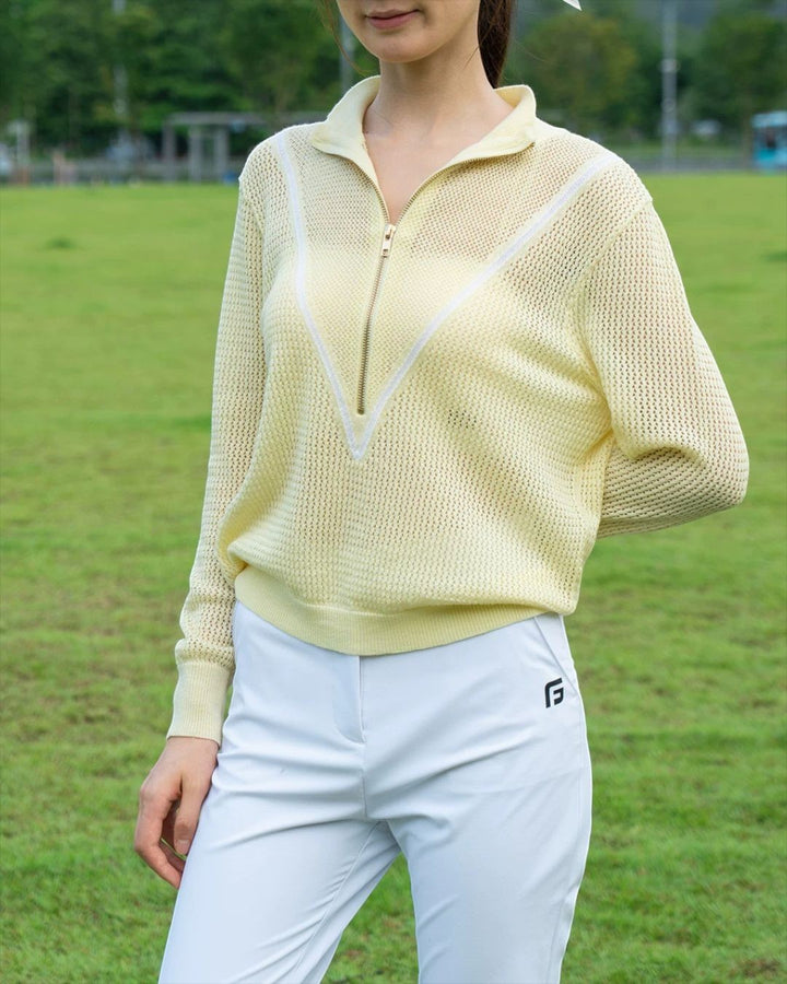 Chamuleの淡いイエローのVラインハーフジップニットと白いボトムスを合わせたゴルフウェアスタイル