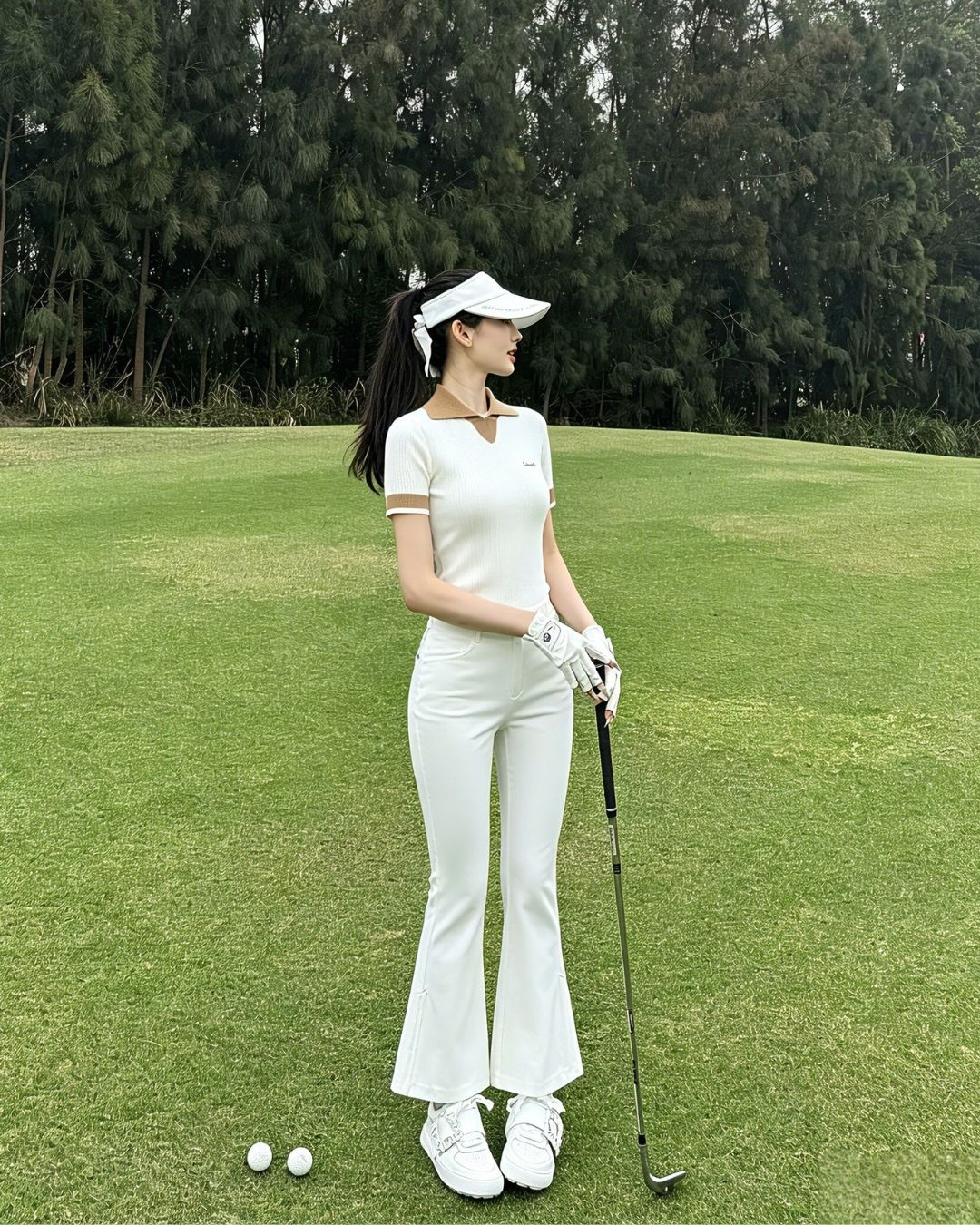 Chamuleのサイドプリーツが揺れるホワイトのフレアゴルフパンツを着用した女性ゴルファー
