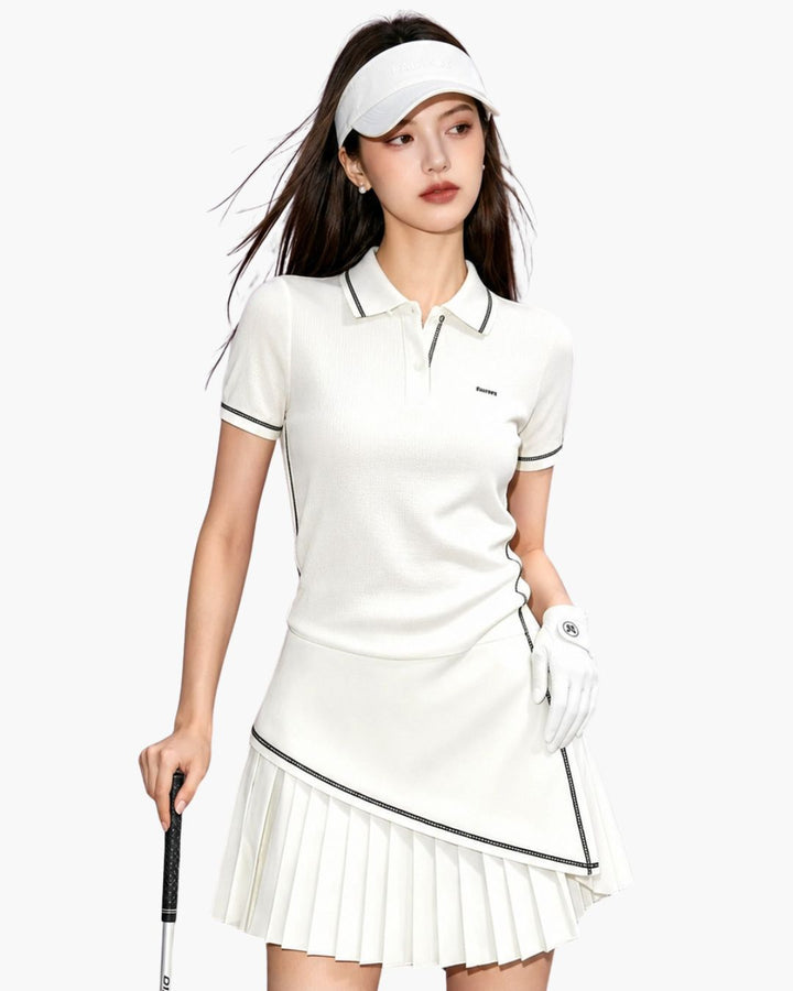 Chamuleのホワイトカラーのアシメプリーツポロゴルフセットアップを着用した女性ゴルファー